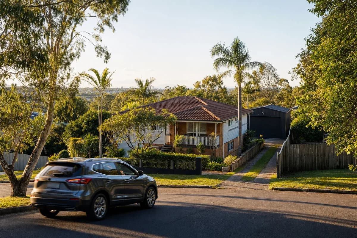 Steel workshop shed behind an established home with a narrow side driveway