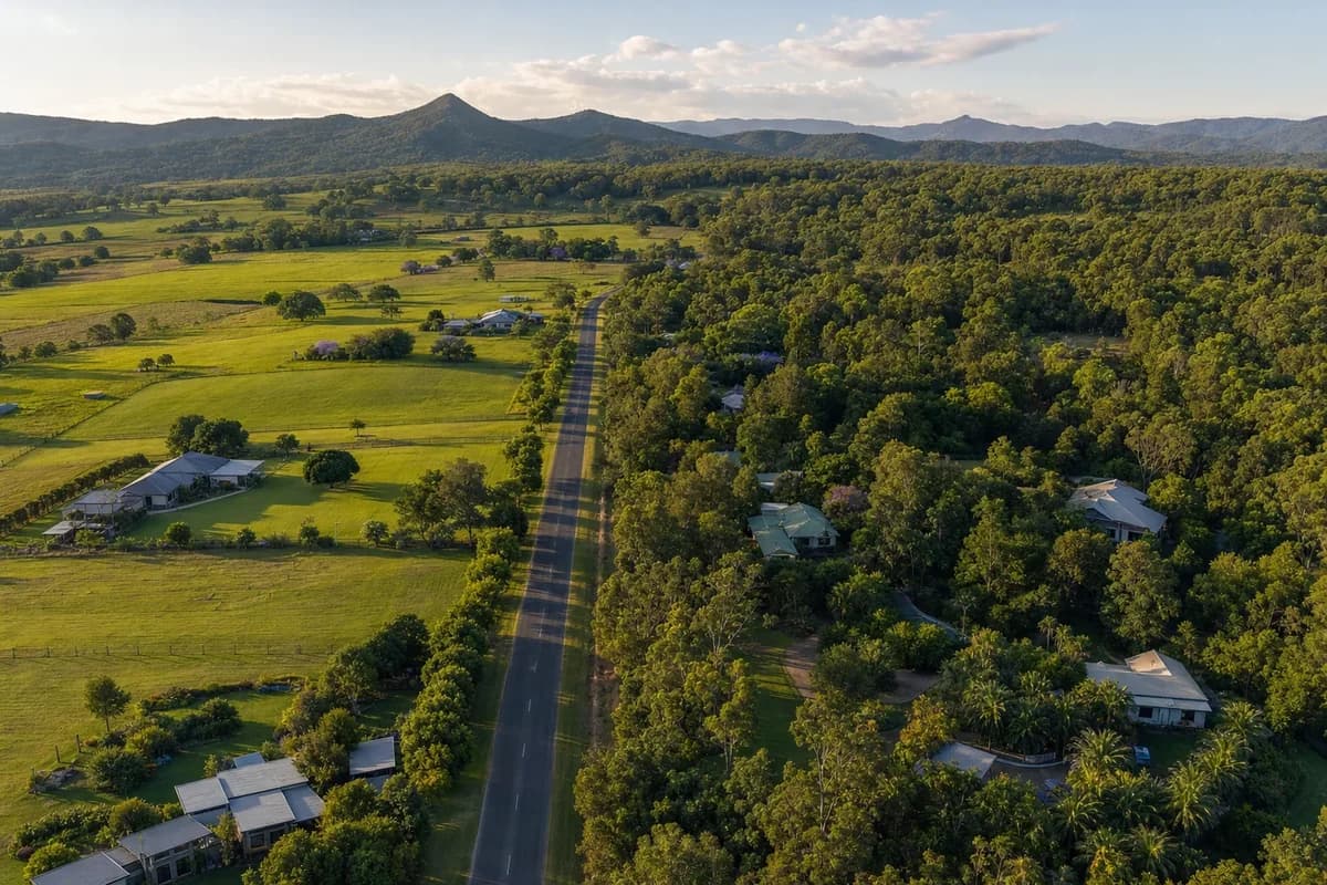 Farmland on one side of a country road and acreage bush on the other, near the Queensland and New South Wales border