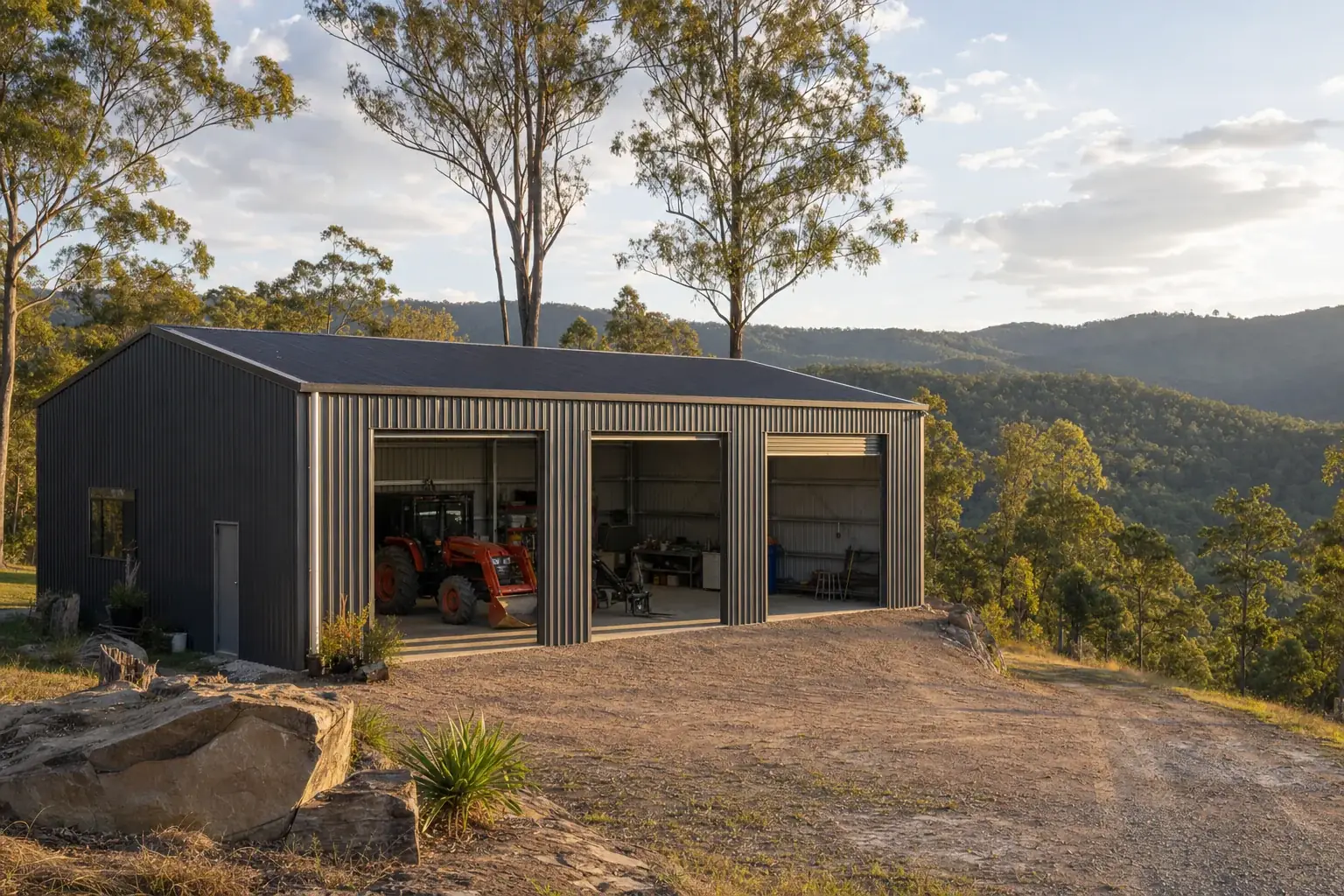 Dark grey machinery shed with a tractor inside, on hillside acreage near Nerang
